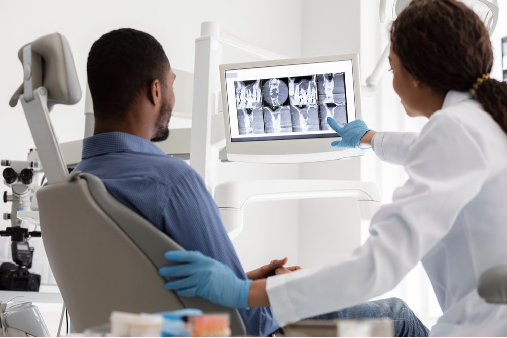 female dentist and male patient watching xray